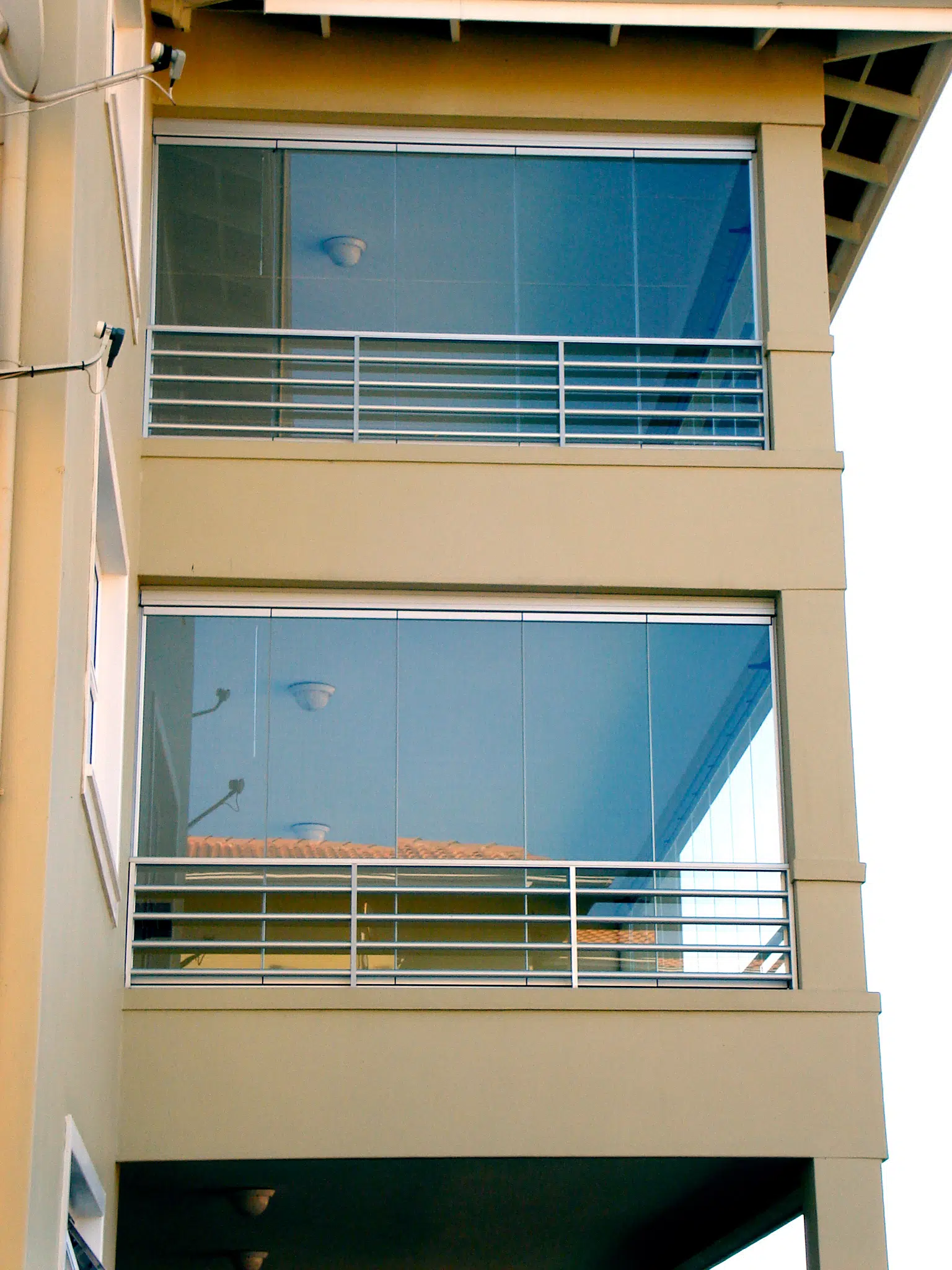Bodentiefe Balkonverglasung vor dem Geländer
