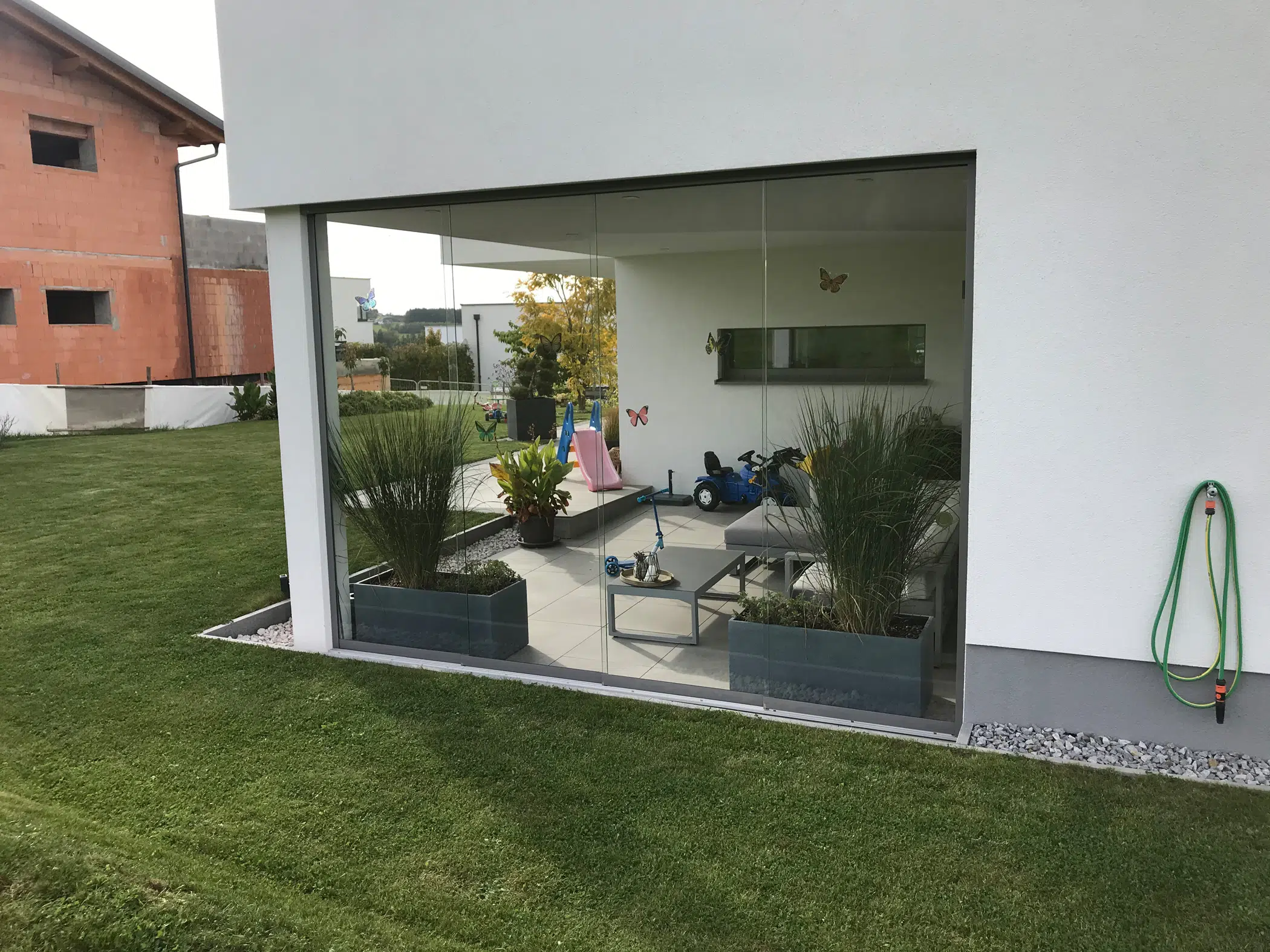 Glasschiebewand für Terrasse als Windschutz in Oberösterreich