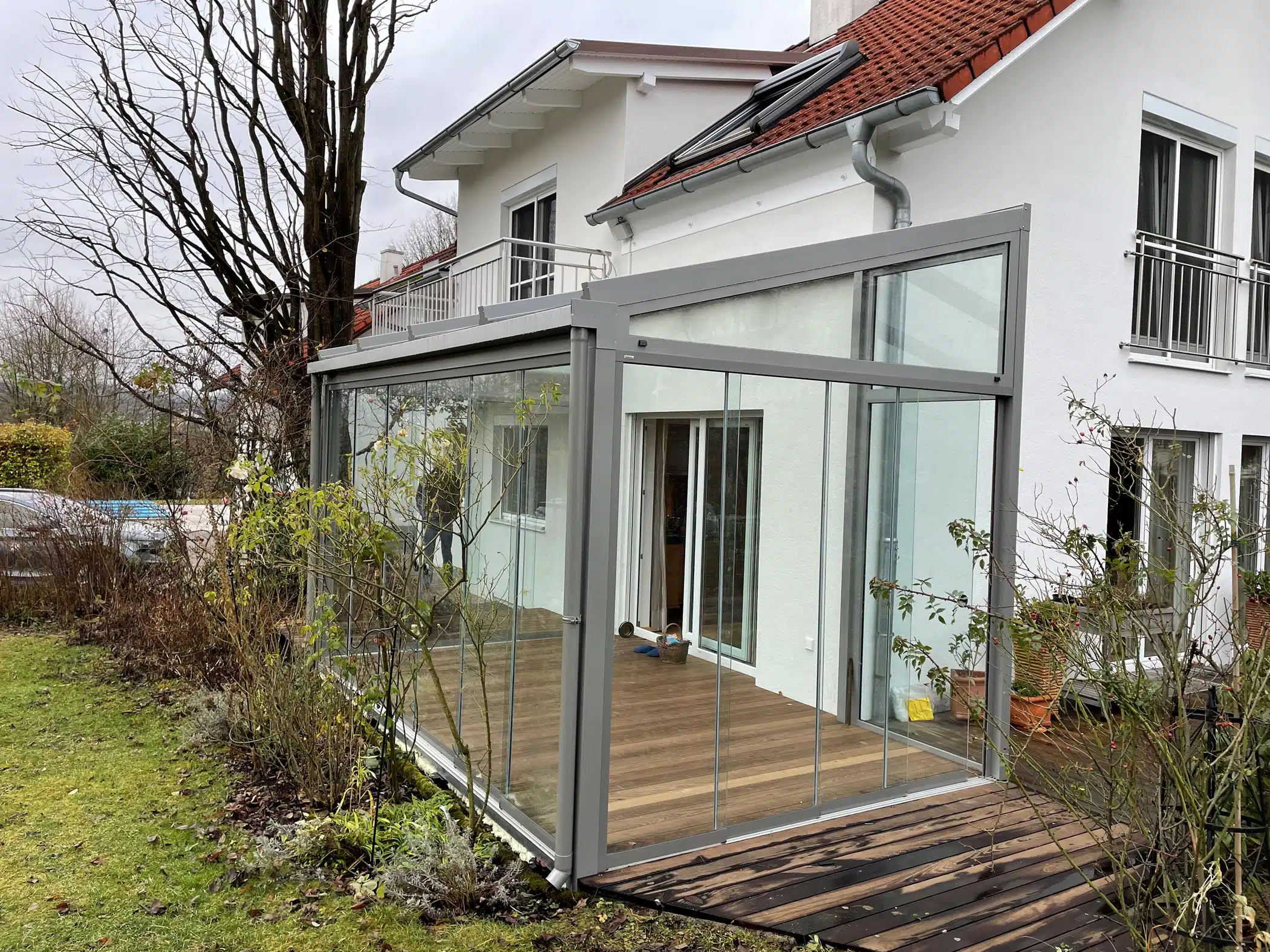 Wintergarten mit Glasschiebetüren an Hauswand montiert